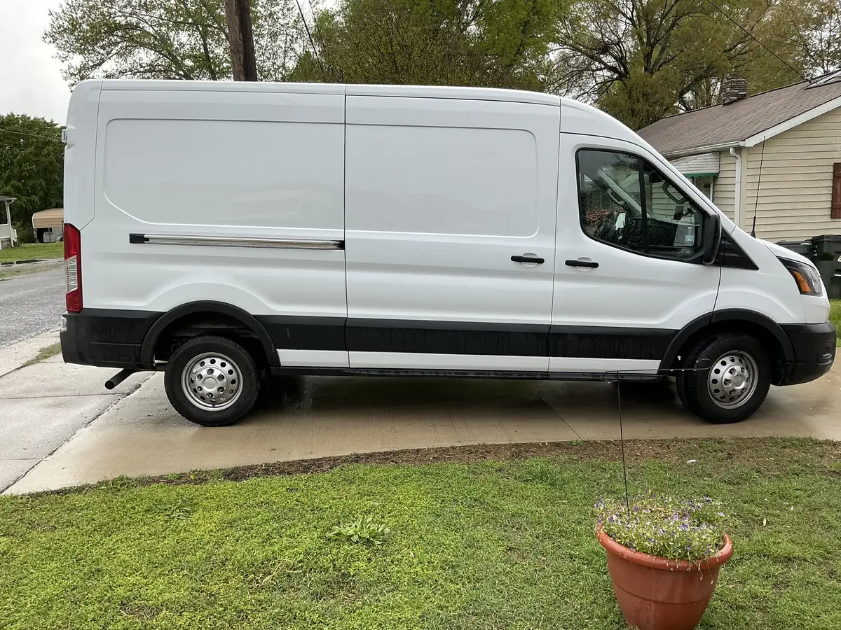 Side profile of the white Sprinter cargo van, passenger side.